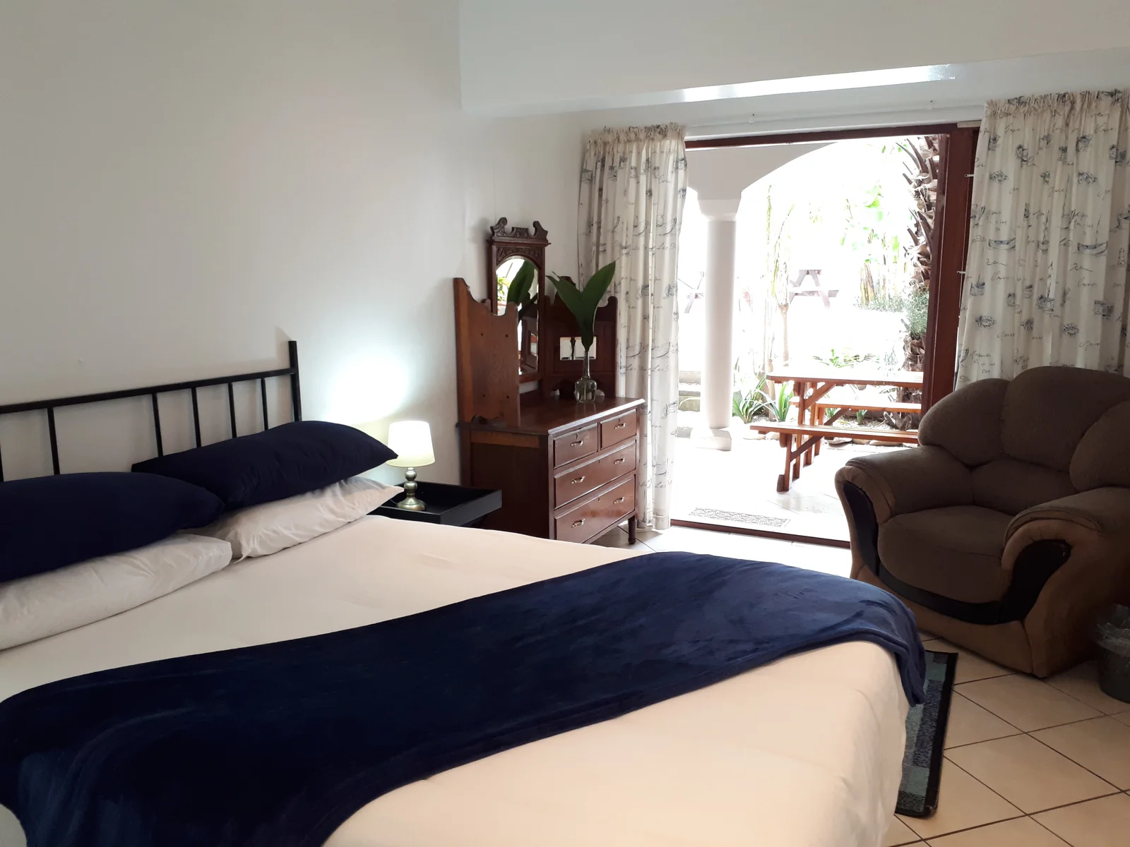 Bright lodge bedroom with two beds opening towards the courtyard